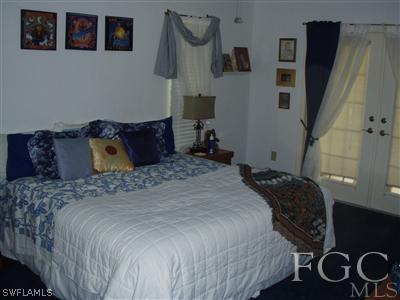 9167 Henry Road Fort Myers, FL 33967 - Photo 8 of 10 a bedroom with a bed and wooden floor