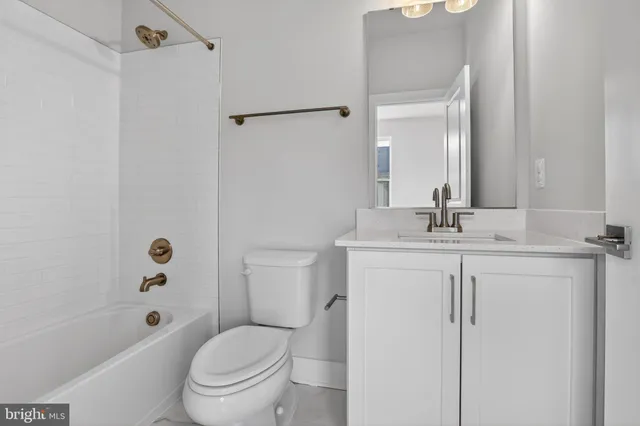 a bathroom with a toilet a sink a mirror a shower and vanity