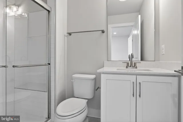 a bathroom with a toilet a sink a vanity and mirror