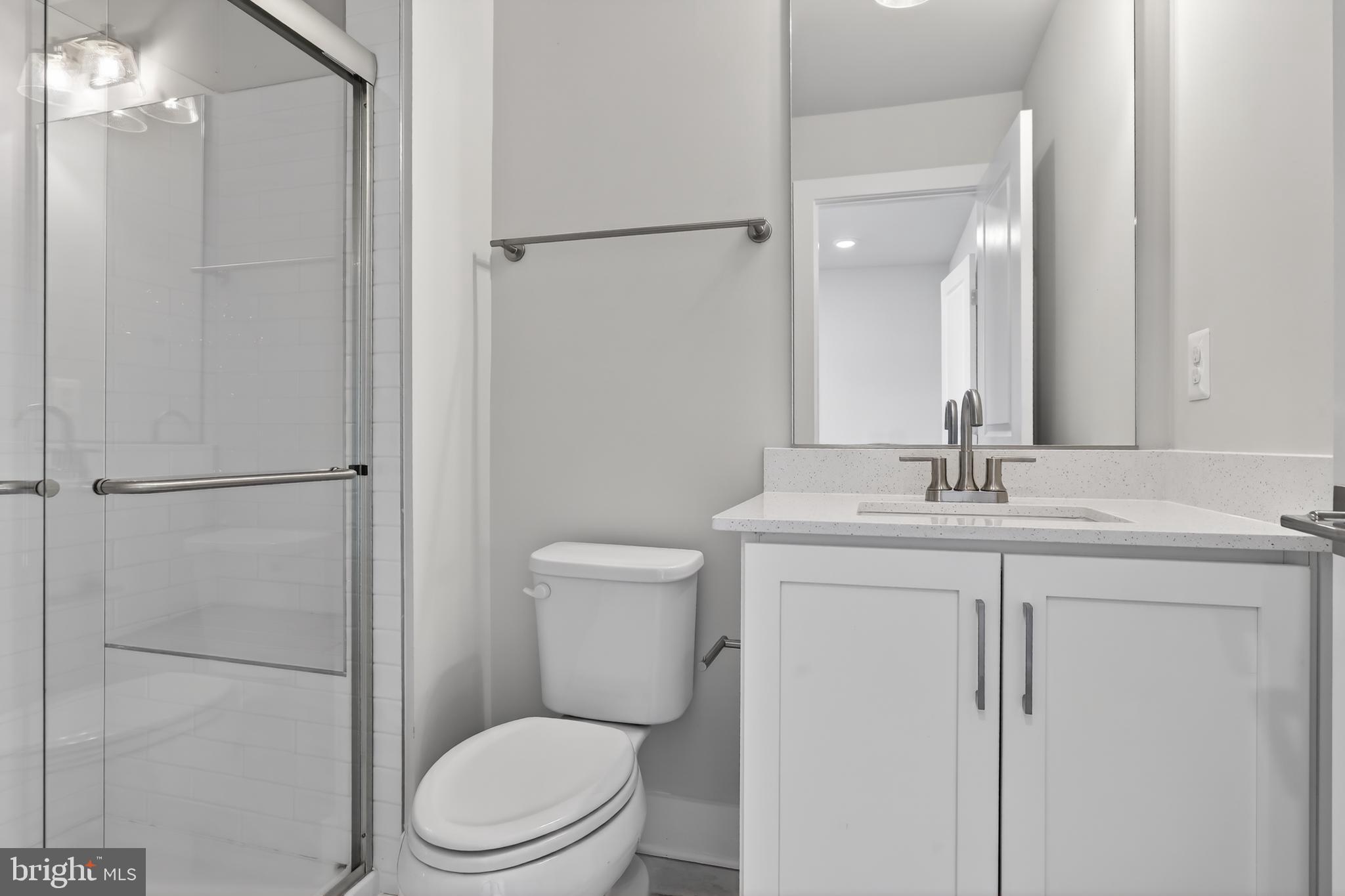 2717 Light Street Baltimore, MD 21230 - Photo 17 of 20 a bathroom with a toilet a sink a vanity and mirror