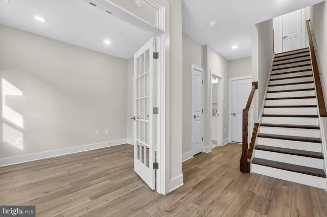 a view of a hallway with wooden floor and stairs