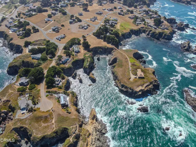 an aerial view of a house with a yard and lake view