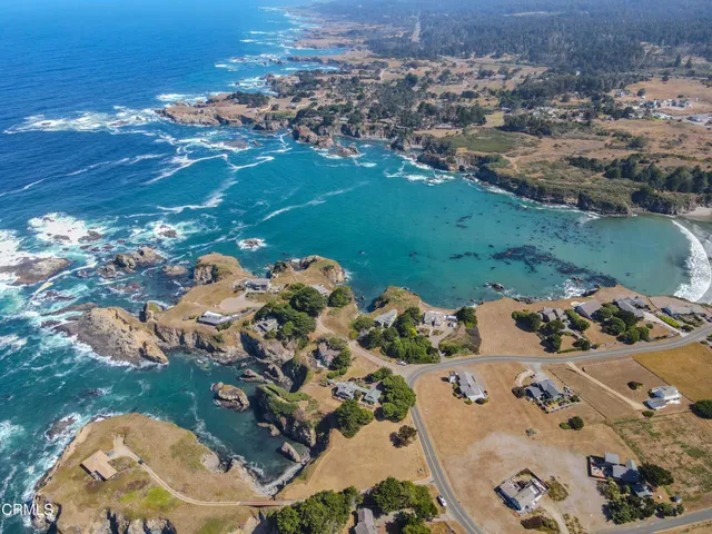 an aerial view of a house with yard and swimming pool