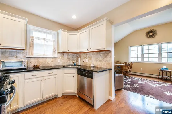 a kitchen with granite countertop white cabinets and white appliances