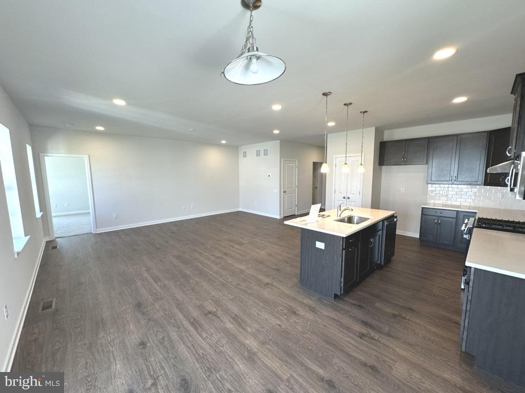 1019 Robinson Road Townsend, DE 19734 - Photo 7 of 13 a large room with a large center island wooden floor stainless steel appliances and living room view