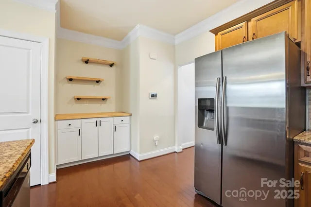 a view of a kitchen with a sink refrigerator and wooden floor