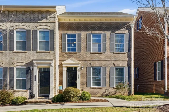 front view of a brick house with a yard