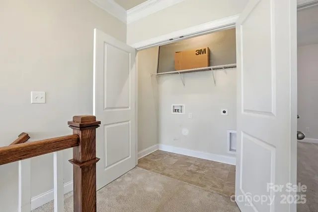 an empty room with a chandelier fan and windows