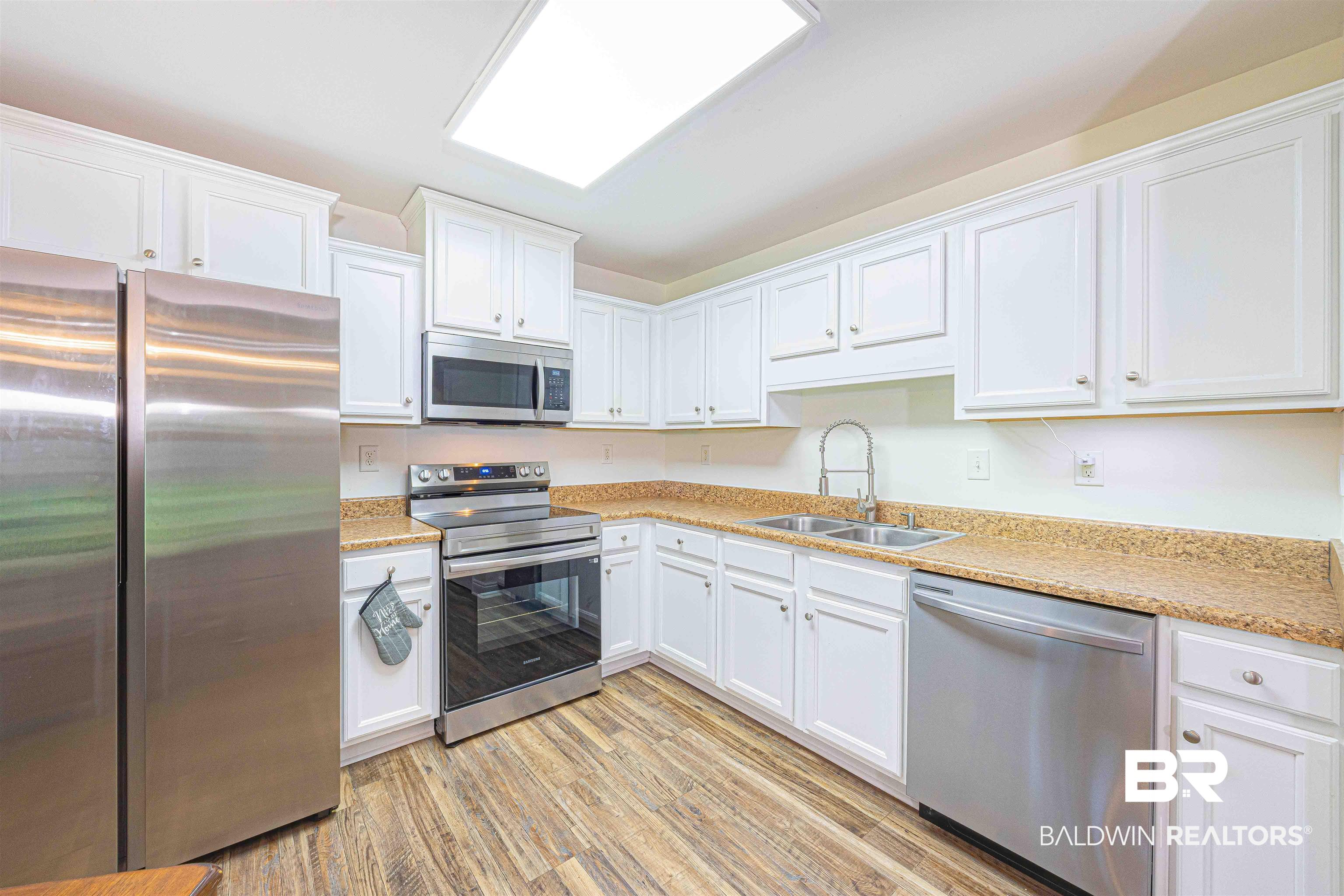 18675 Explorer Drive Loxley, AL 36551 - Photo 11 of 42 Kitchen with appliances with stainless steel finishes, a sink, white cabinetry, and light countertops