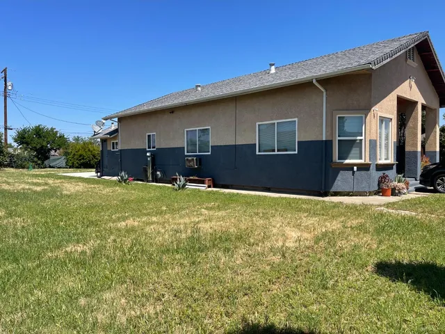 a backyard of a house with yard and outdoor seating
