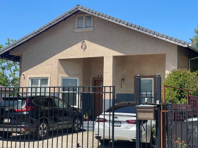 a front view of a house with a garden and trees