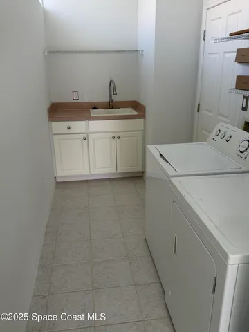 a utility room with a sink washer and dryer