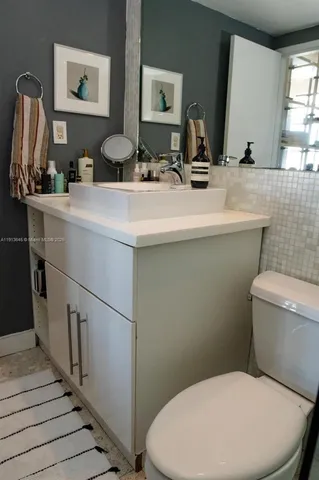 a bathroom with a toilet a sink and mirror