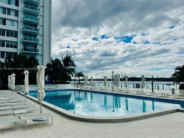 a view of swimming pool with outdoor seating and city view