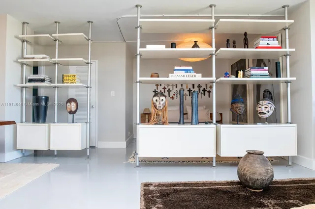 a living room with lots of clutter and cabinets