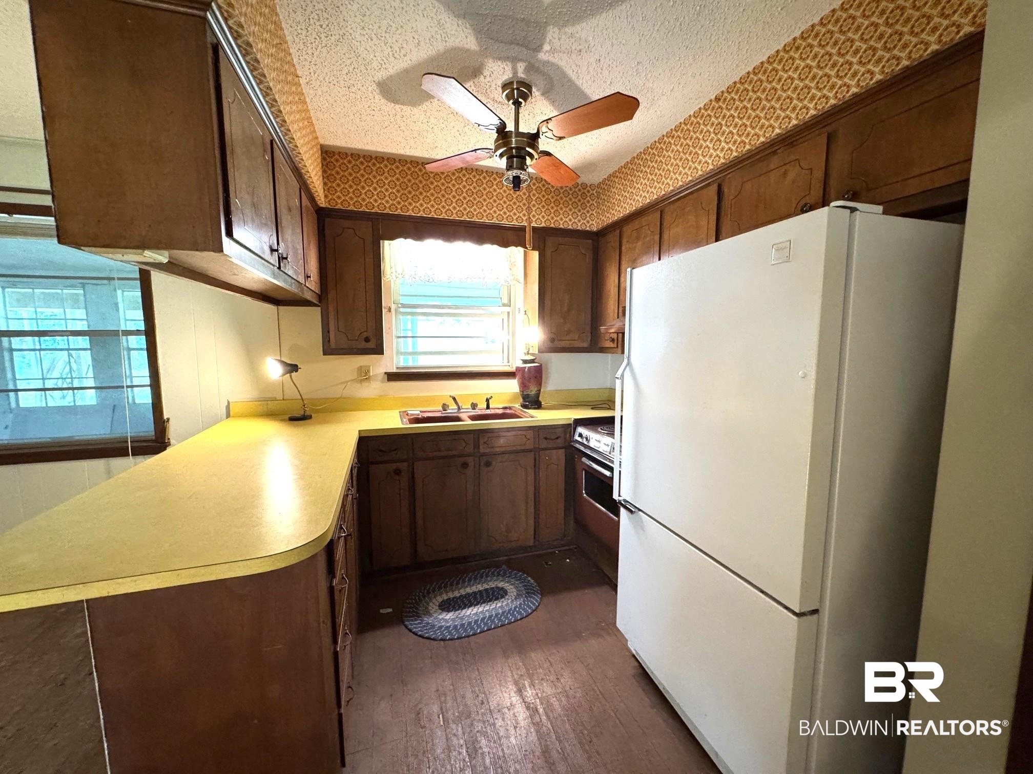 5198 Lancelot Drive Mobile, AL 36619 - Photo 4 of 30 Kitchen with freestanding refrigerator, dark wood-style flooring, a ceiling fan, light countertops, and a textured ceiling