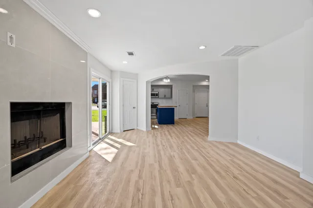 a view of empty room with a fireplace and wooden floor
