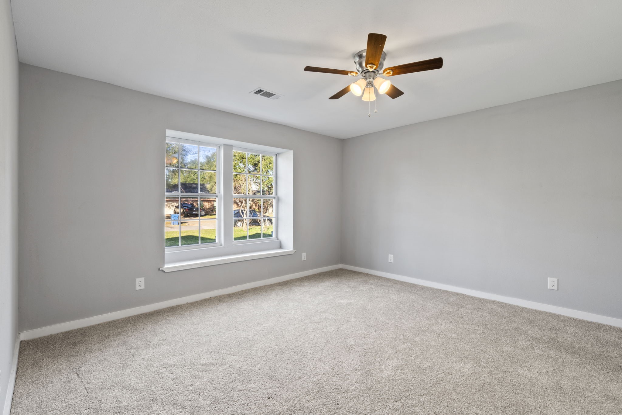 1740 6th Street Hempstead, TX 77445 - Photo 6 of 22 Spacious primary bedroom with fresh carpet, neutral tones, and natural light—designed for comfort and relaxation.