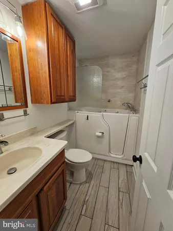 a bathroom with a granite countertop sink a toilet and a mirror