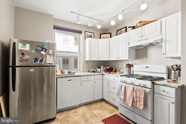 a kitchen with stainless steel appliances granite countertop a refrigerator sink and cabinets