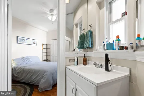 a bedroom with a sink and a mirror