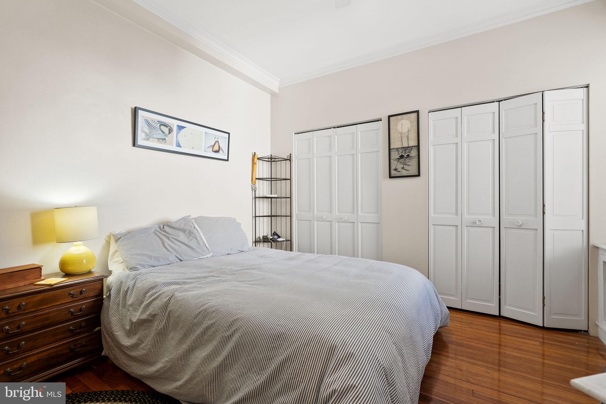 3405 Greenway, Unit 302 Baltimore, MD 21218 - Photo 27 of 42 a bedroom with a bed and wooden floor