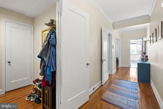 a view of a hallway with wooden floor and closet
