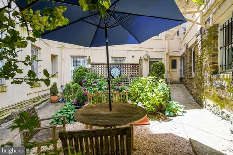 a view of a patio with table and chairs under an umbrella