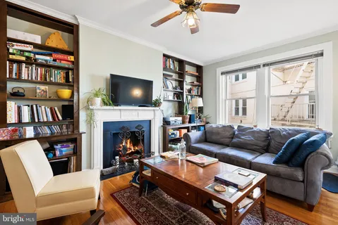 a living room with furniture a fireplace and a flat screen tv