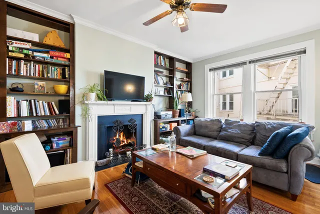 a living room with furniture a fireplace and a flat screen tv