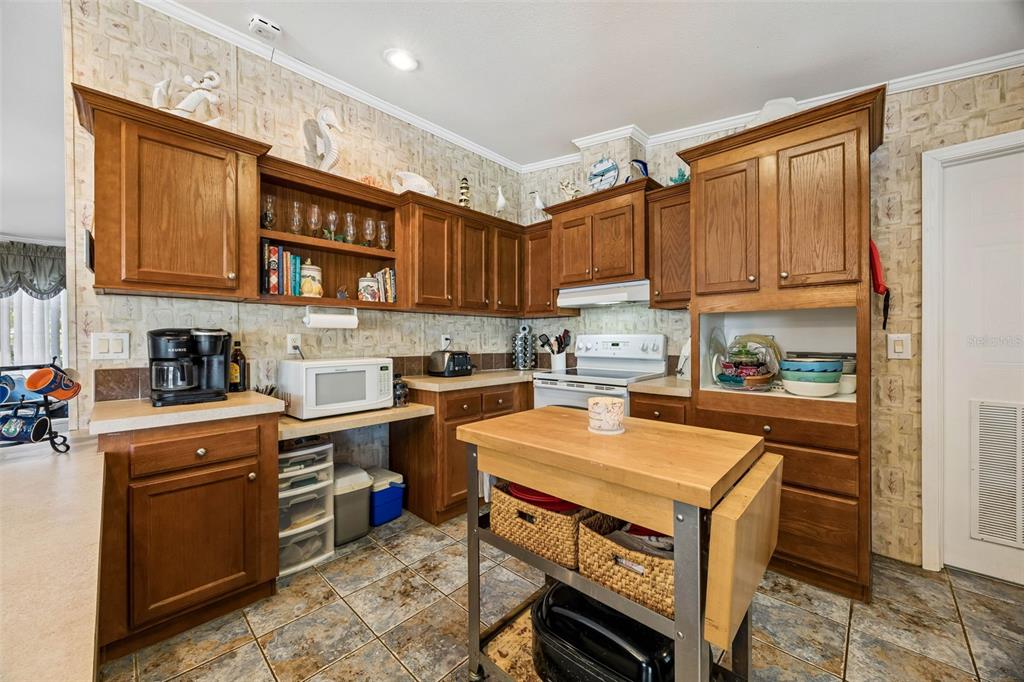 334 Paradise Circle Satsuma, FL 32189 - Photo 15 of 40 a kitchen with stainless steel appliances granite countertop a stove top oven a sink dishwasher and a refrigerator with wooden cabinets