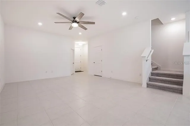 wooden floor in an empty room with a ceiling fan