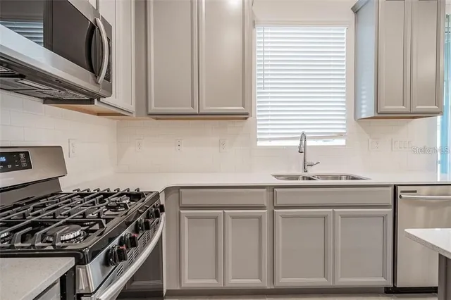 a kitchen with white cabinets and appliances