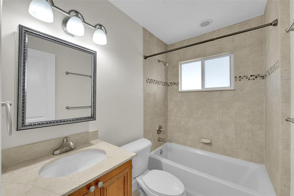 410 Southwest 15th Street, Unit 103 Pompano Beach, FL 33060 - Photo 12 of 16 a bathroom with a bathtub shower sink vanity mirror and toilet