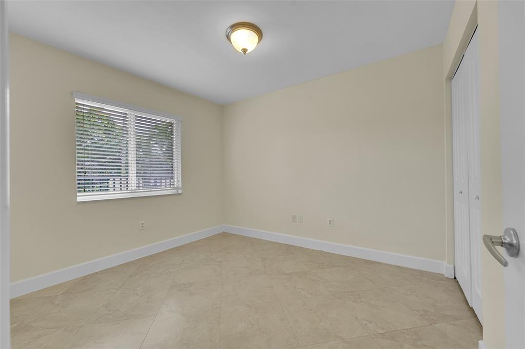 410 Southwest 15th Street, Unit 103 Pompano Beach, FL 33060 - Photo 13 of 16 an empty room with a window