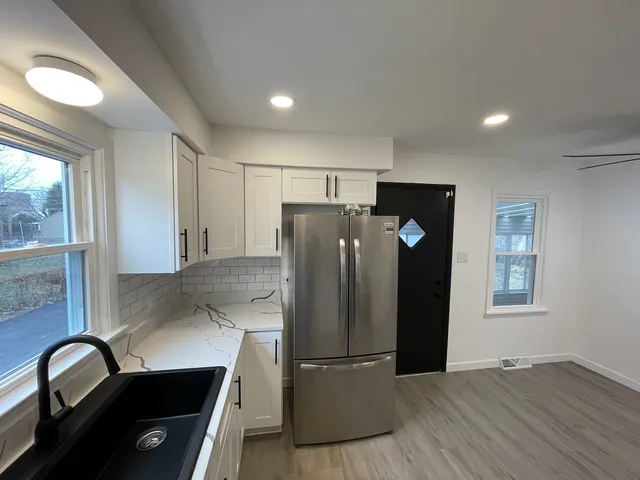 a kitchen with stainless steel appliances granite countertop a refrigerator and a sink