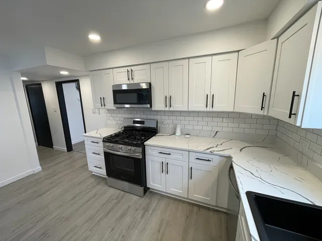 a kitchen with a sink stove and white cabinets