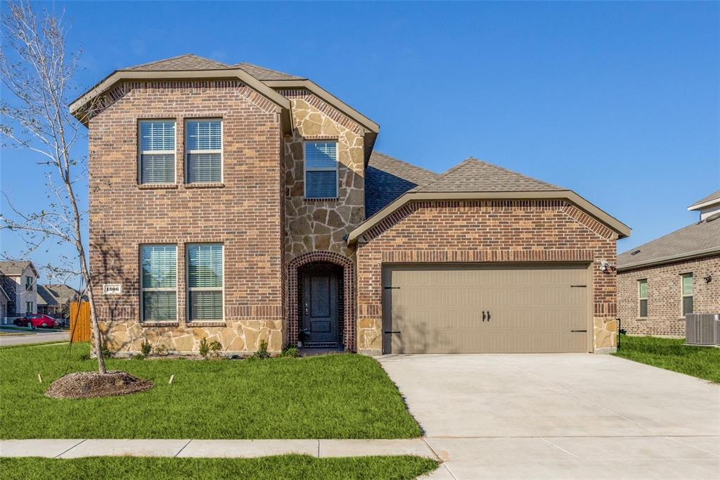 1306 Colonial Bluff Lane Princeton, TX 75407 - Photo 1 of 27 Two-story brick and stone facade residence featuring a two-car garage, arched entry, and dark-paneled front door