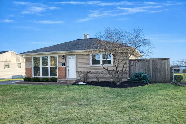 a front view of a house with a garden and yard