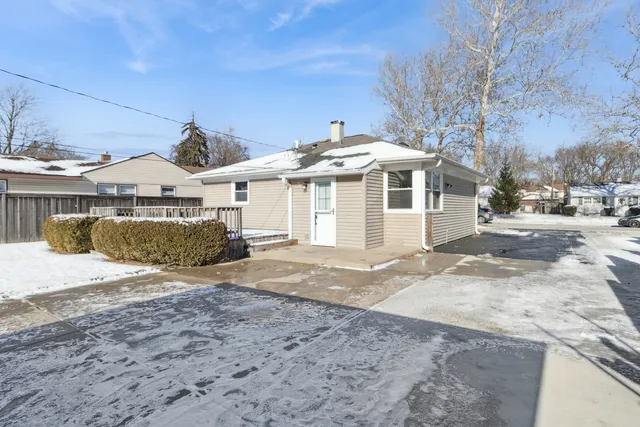a front view of a house with a dirt yard and a garage