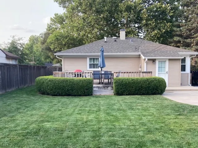 a view of a house with a yard and large tree