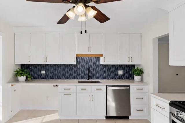 a kitchen with white cabinets and chandelier