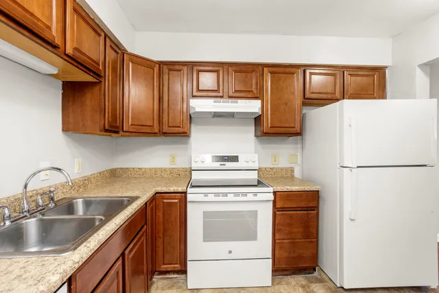 a kitchen with a refrigerator sink and cabinets