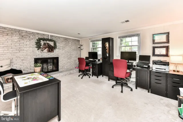 a view of a workspace with furniture and a window