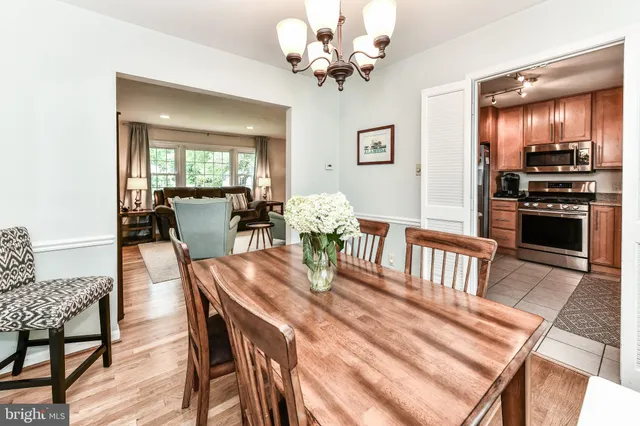 a view of a dining room with furniture a chandelier and wooden floor