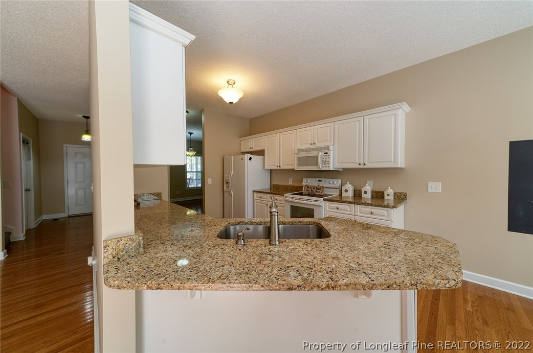 60 Spring Lake Drive Pinehurst, NC 28374 - Photo 18 of 38 a kitchen with stainless steel appliances granite countertop a sink refrigerator and cabinets