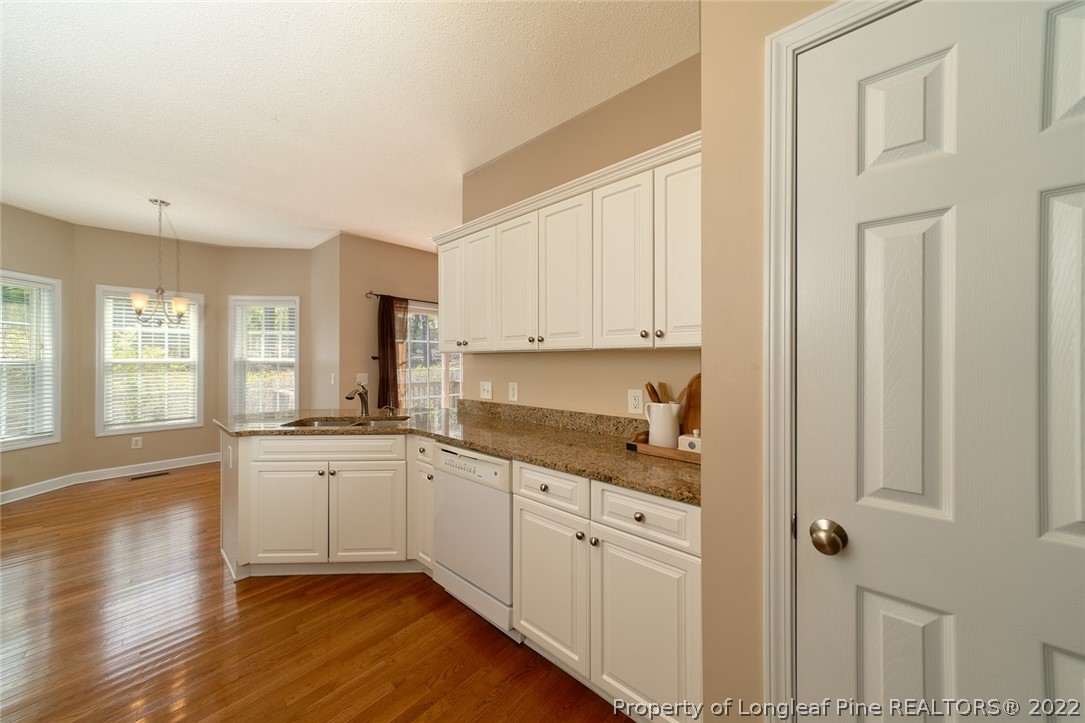 60 Spring Lake Drive Pinehurst, NC 28374 - Photo 19 of 38 a kitchen with granite countertop white cabinets and white appliances