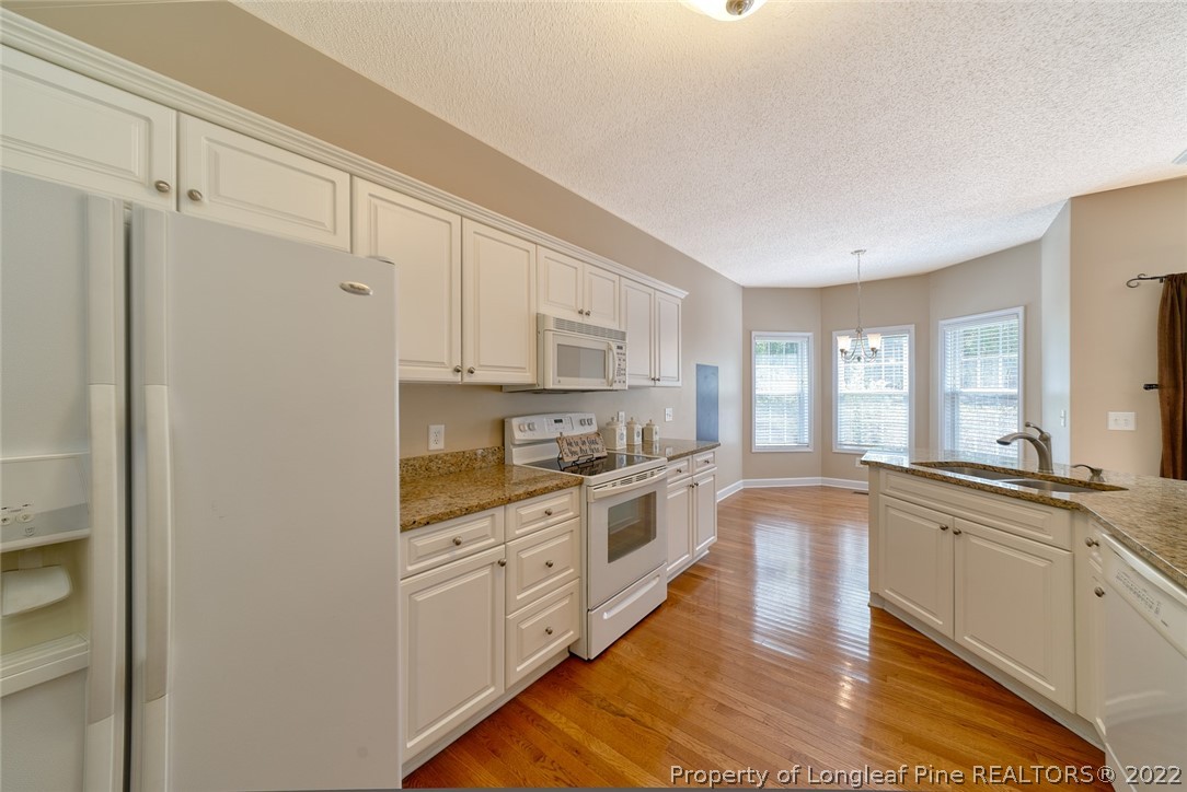 60 Spring Lake Drive Pinehurst, NC 28374 - Photo 20 of 38 a large kitchen with stainless steel appliances granite countertop a stove a sink and white cabinets