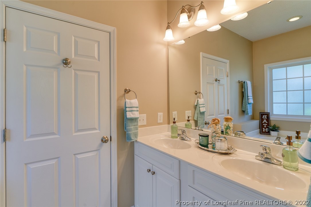 60 Spring Lake Drive Pinehurst, NC 28374 - Photo 25 of 38 a bathroom with a double vanity sink and a mirror