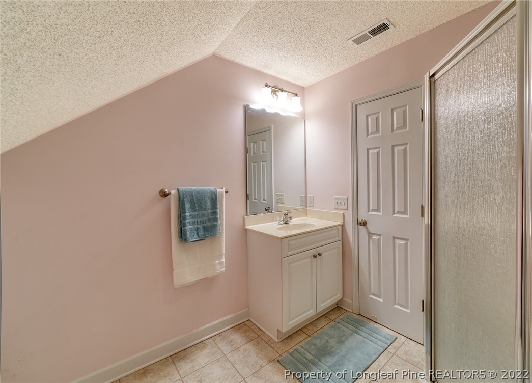 60 Spring Lake Drive Pinehurst, NC 28374 - Photo 31 of 38 a bathroom with a granite countertop sink and mirror